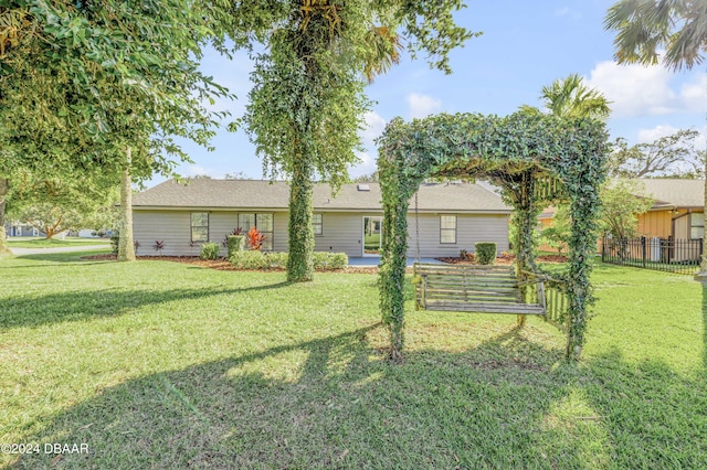 rear view of property featuring a lawn