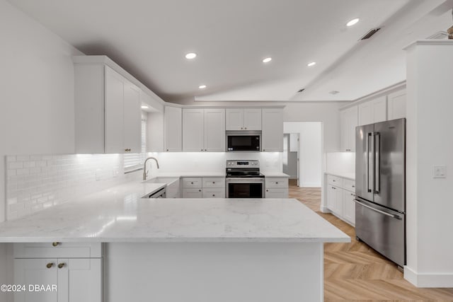 kitchen with kitchen peninsula, white cabinetry, light parquet floors, and appliances with stainless steel finishes