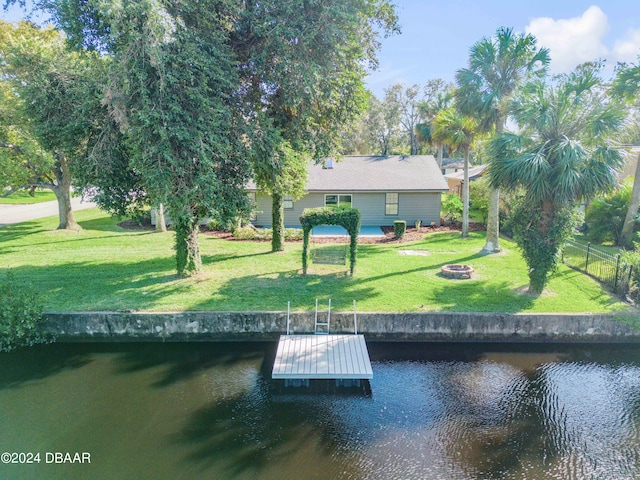 view of dock featuring a yard, a water view, and a fire pit