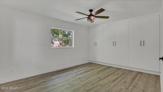 unfurnished bedroom featuring a closet, light hardwood / wood-style floors, and ceiling fan