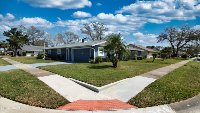 view of front of house featuring an attached garage, a chimney, and a front lawn