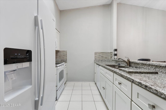 kitchen with sink, white cabinets, white appliances, light stone countertops, and backsplash