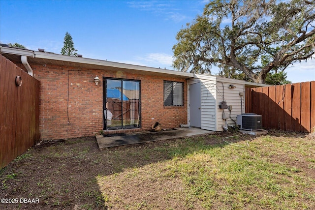 back of house featuring a lawn and central air condition unit