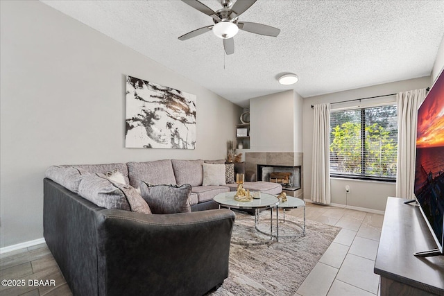 tiled living room featuring a textured ceiling, ceiling fan, and a multi sided fireplace