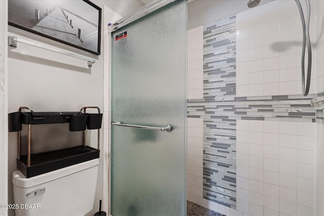 bathroom featuring toilet and a shower with door