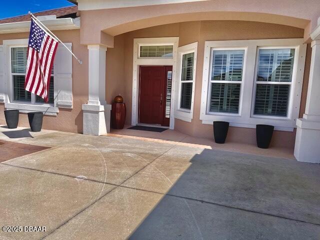 doorway to property with stucco siding and a patio area