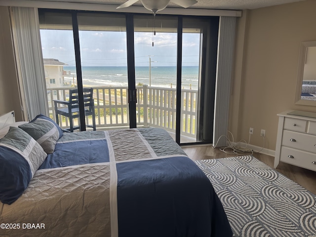 3580 S Ocean Shore Blvd Unit 404, Flagler Beach, FL 32136 - bedroom with access to exterior, wood finished floors, multiple windows, and view of water and beach