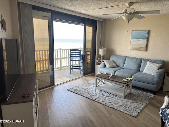 3580 S Ocean Shore Blvd Unit 404, Flagler Beach, FL 32136 - living area featuring ceiling fan, wood finished floors, and a water view