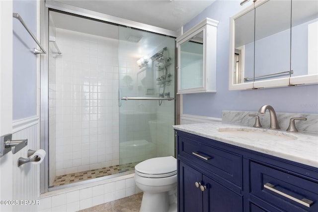 bathroom with vanity, a shower with shower door, and toilet