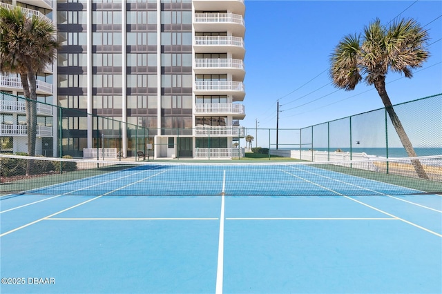 view of tennis court featuring a water view