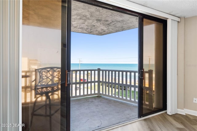 balcony featuring a beach view and a water view