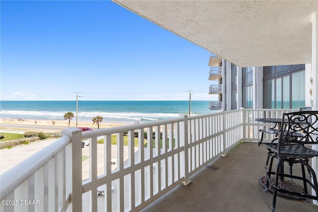 balcony with a beach view and a water view