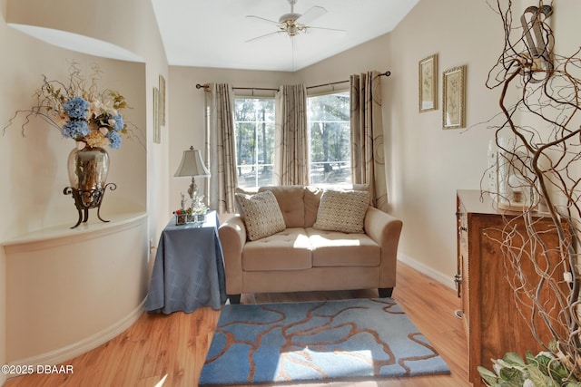 sitting room with ceiling fan and wood-type flooring