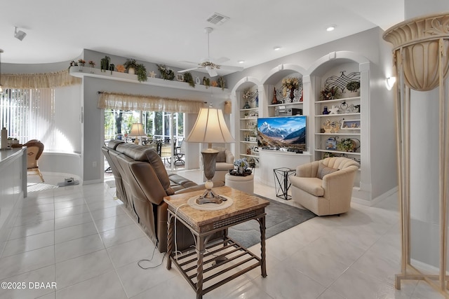 living room featuring a healthy amount of sunlight, light tile patterned floors, built in features, and ceiling fan