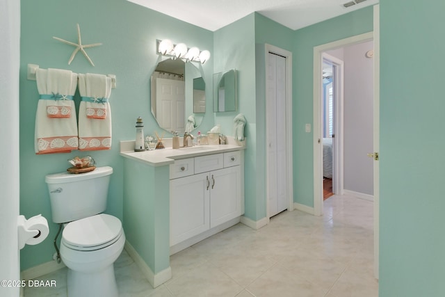 bathroom featuring vanity, tile patterned floors, and toilet