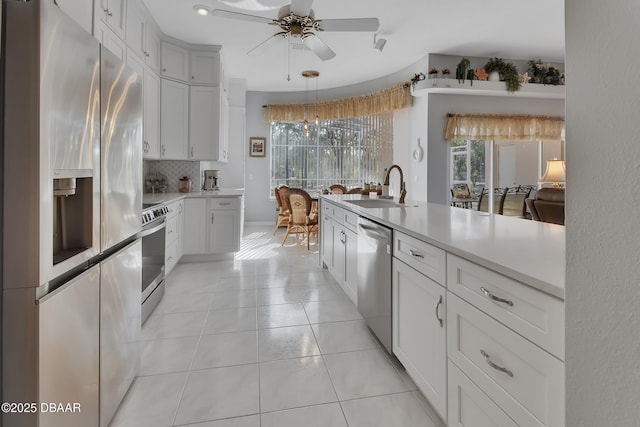 kitchen featuring pendant lighting, sink, appliances with stainless steel finishes, white cabinetry, and light tile patterned flooring