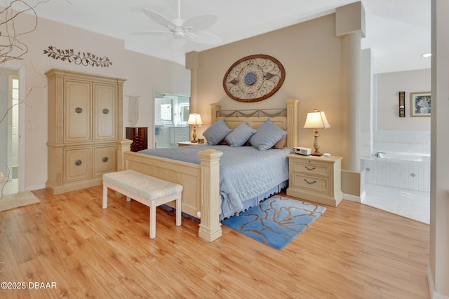 bedroom with connected bathroom, light hardwood / wood-style flooring, and decorative columns