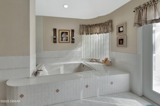 bathroom featuring tiled bath, tile patterned flooring, and a wealth of natural light