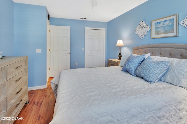 bedroom with ceiling fan, light wood-type flooring, and a closet