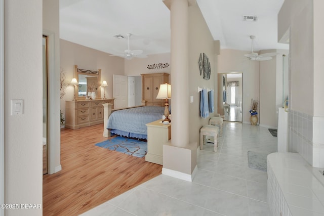 tiled bedroom featuring ornate columns, ceiling fan, and high vaulted ceiling