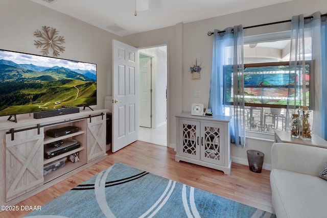 living room featuring ceiling fan and light wood-type flooring