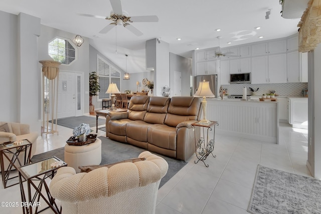 tiled living room featuring ceiling fan and high vaulted ceiling