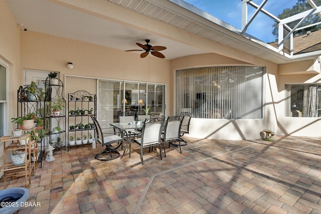 view of patio featuring ceiling fan and glass enclosure