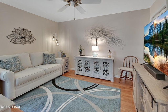 living room featuring ceiling fan and light hardwood / wood-style floors