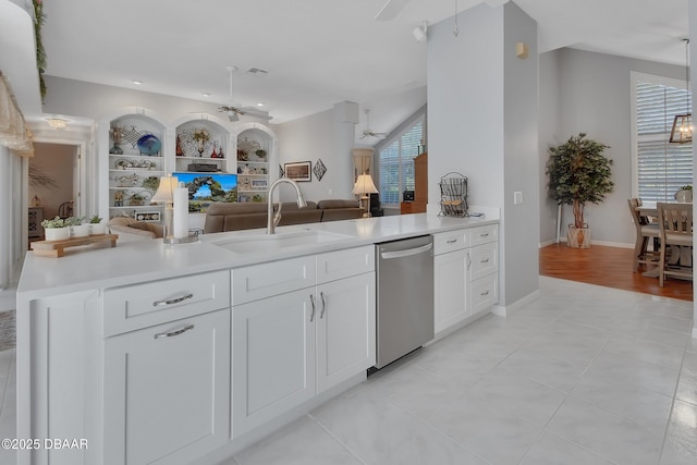 kitchen featuring sink, light tile patterned floors, stainless steel dishwasher, ceiling fan, and white cabinets