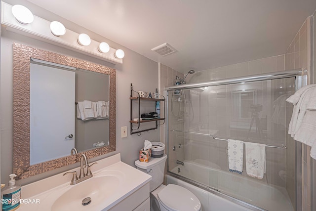 full bathroom with toilet, vanity, and enclosed tub / shower combo