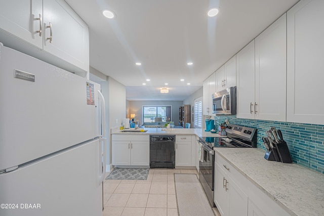 kitchen featuring tasteful backsplash, stainless steel appliances, light tile patterned floors, light stone countertops, and white cabinets