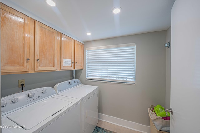 laundry room featuring cabinets, light tile patterned floors, and separate washer and dryer