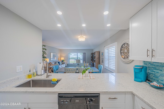 kitchen with white cabinets, sink, backsplash, and black dishwasher