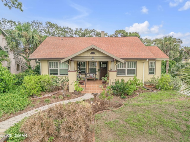 view of front of home with a front yard and covered porch