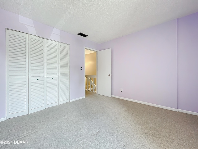 unfurnished bedroom featuring a textured ceiling and a closet