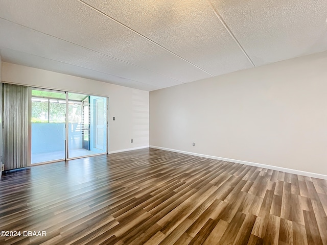 unfurnished room featuring hardwood / wood-style floors and a textured ceiling