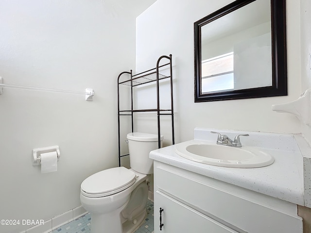 bathroom with tile patterned flooring, vanity, and toilet