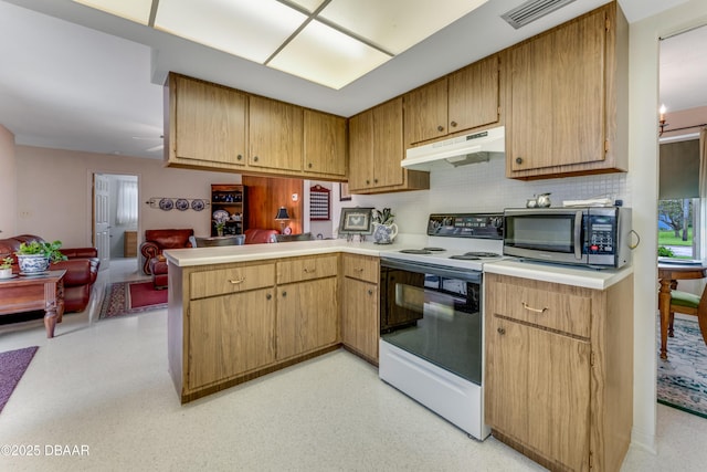 1713 Caldwell Rd, South Daytona, FL 32119 - kitchen featuring stainless steel microwave, under cabinet range hood, electric range, a peninsula, and light countertops