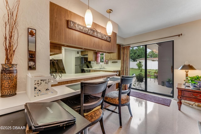 1713 Caldwell Rd, South Daytona, FL 32119 - kitchen with freestanding refrigerator, light countertops, a sink, a textured wall, and hanging light fixtures