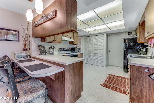 1713 Caldwell Rd, South Daytona, FL 32119 - kitchen with under cabinet range hood, electric stove, a sink, light countertops, and a peninsula