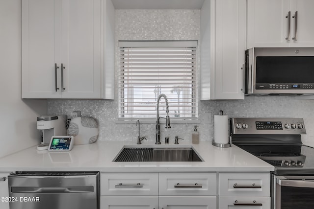 kitchen featuring white cabinetry, sink, appliances with stainless steel finishes, and tasteful backsplash