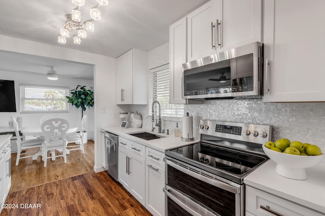 kitchen with white cabinetry, sink, appliances with stainless steel finishes, dark wood-type flooring, and decorative backsplash