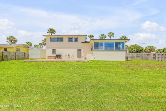 rear view of house with a patio and a yard