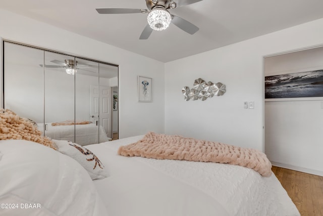 bedroom with hardwood / wood-style flooring, ceiling fan, and a closet