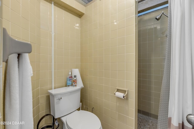 bathroom featuring toilet and a tile shower