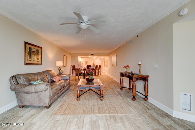 living room with light hardwood / wood-style floors, ceiling fan, a textured ceiling, and crown molding