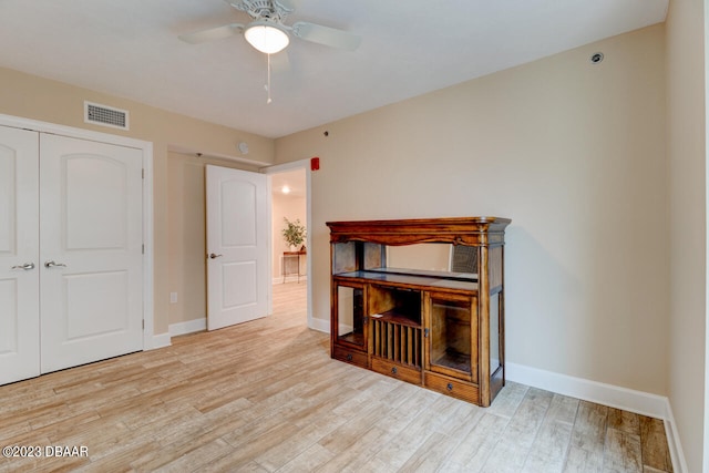 unfurnished bedroom with light hardwood / wood-style floors, ceiling fan, and a closet