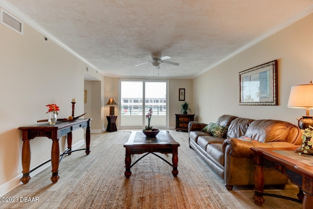 living room with ceiling fan, a textured ceiling, light hardwood / wood-style floors, and crown molding