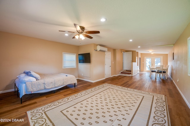 bedroom featuring hardwood / wood-style flooring, ceiling fan, an AC wall unit, and french doors