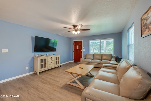 living room with hardwood / wood-style floors, ceiling fan, and a textured ceiling